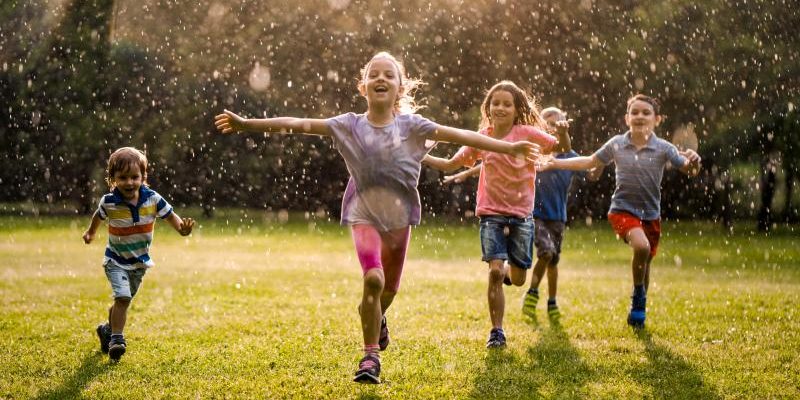 Kids running together playing at the backyard