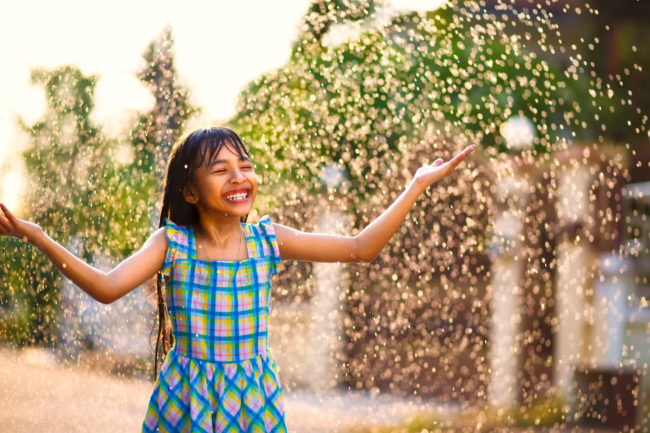 Happy girl enjoying the summer rain