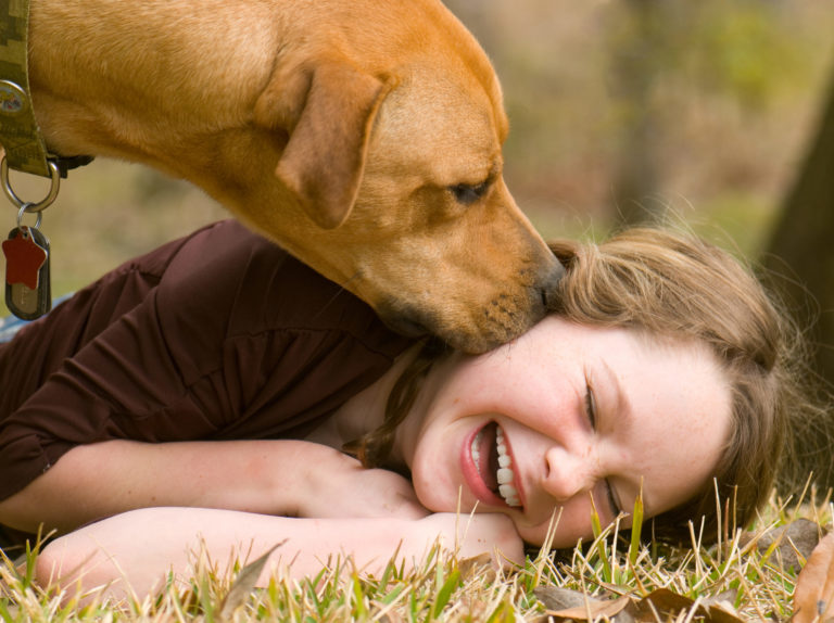 Dog kissing a girl on the cheeks